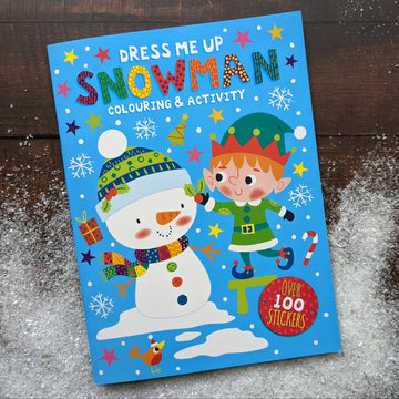 Children's activity book titled 'Dress Me Up Snowman' with a snowman and elf illustration on a wooden surface.