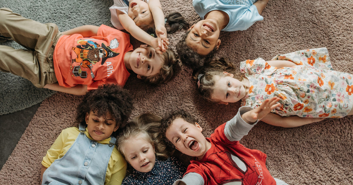 Group of children on the floor all happy in the clothes they are in
