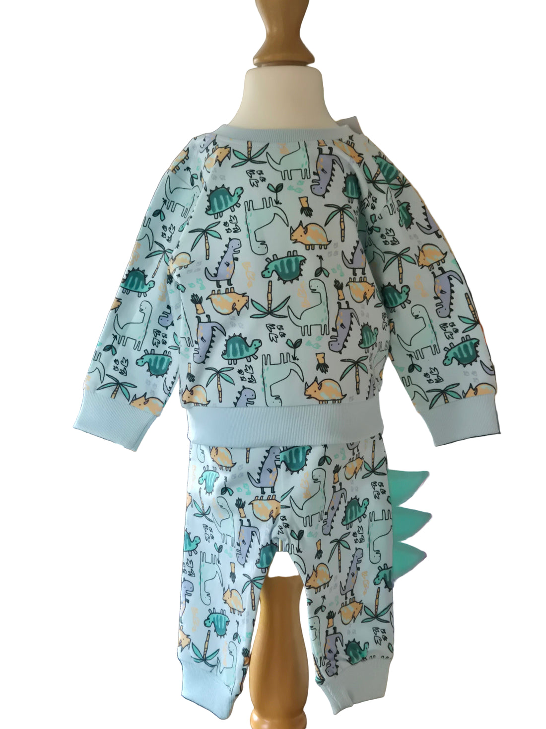 Children's outfit with dinosaur pattern on a mannequin against a white background