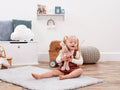 Child sitting on a rug in a room with toys and furniture