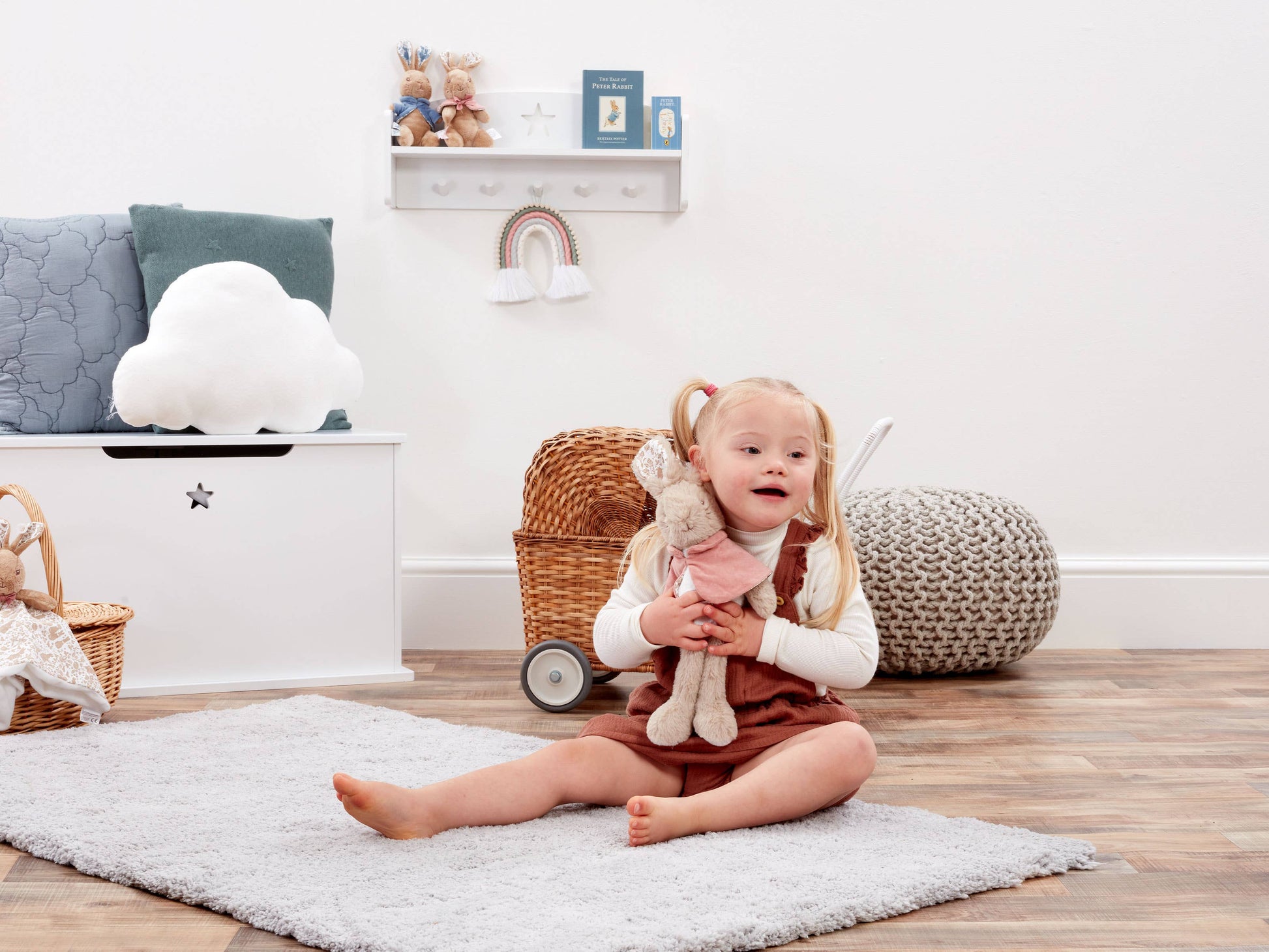 Child sitting on a rug in a room with toys and furniture