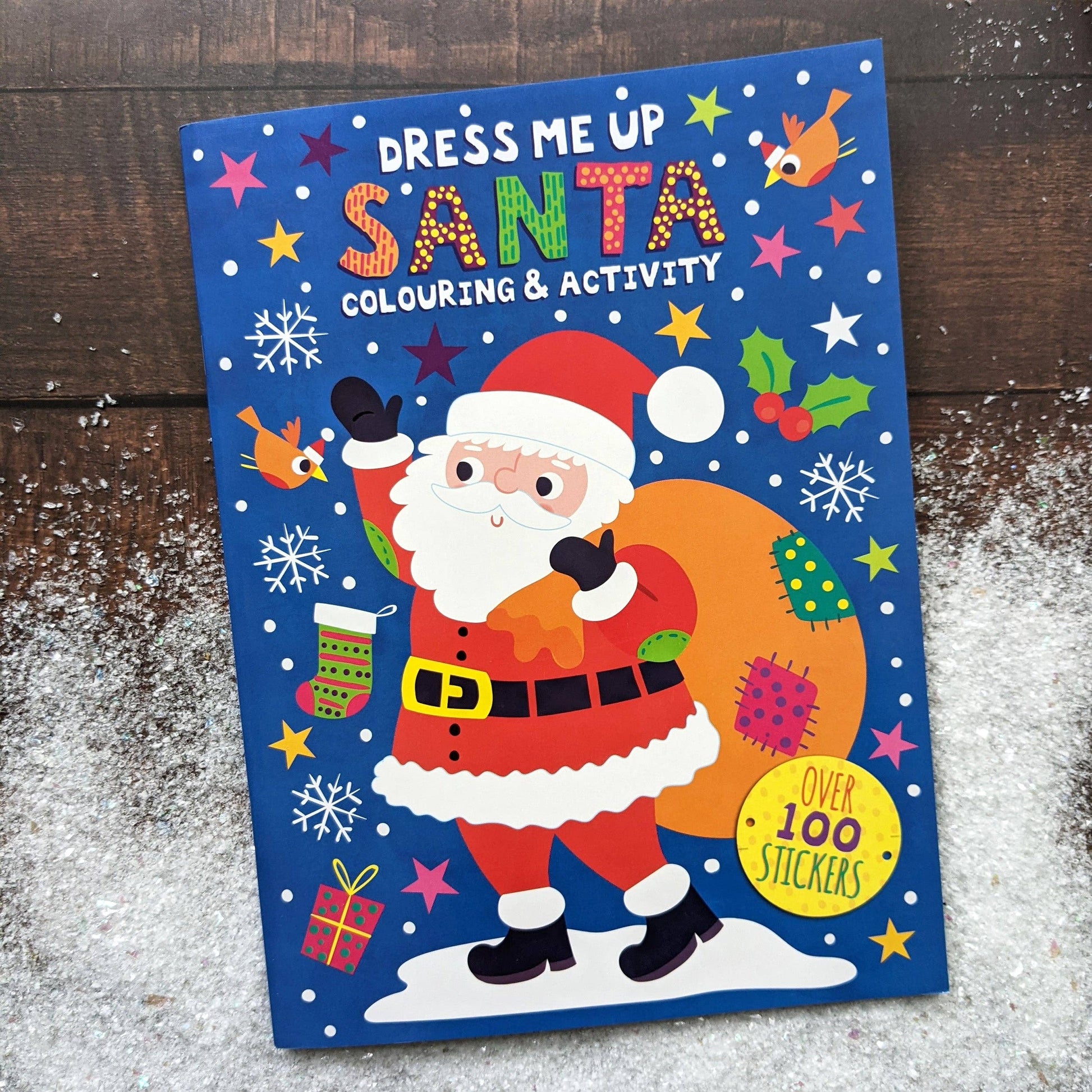 Coloring book cover with Santa Claus on a wooden surface with snow.