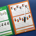 Educational book with math problems and a marker on a blue background