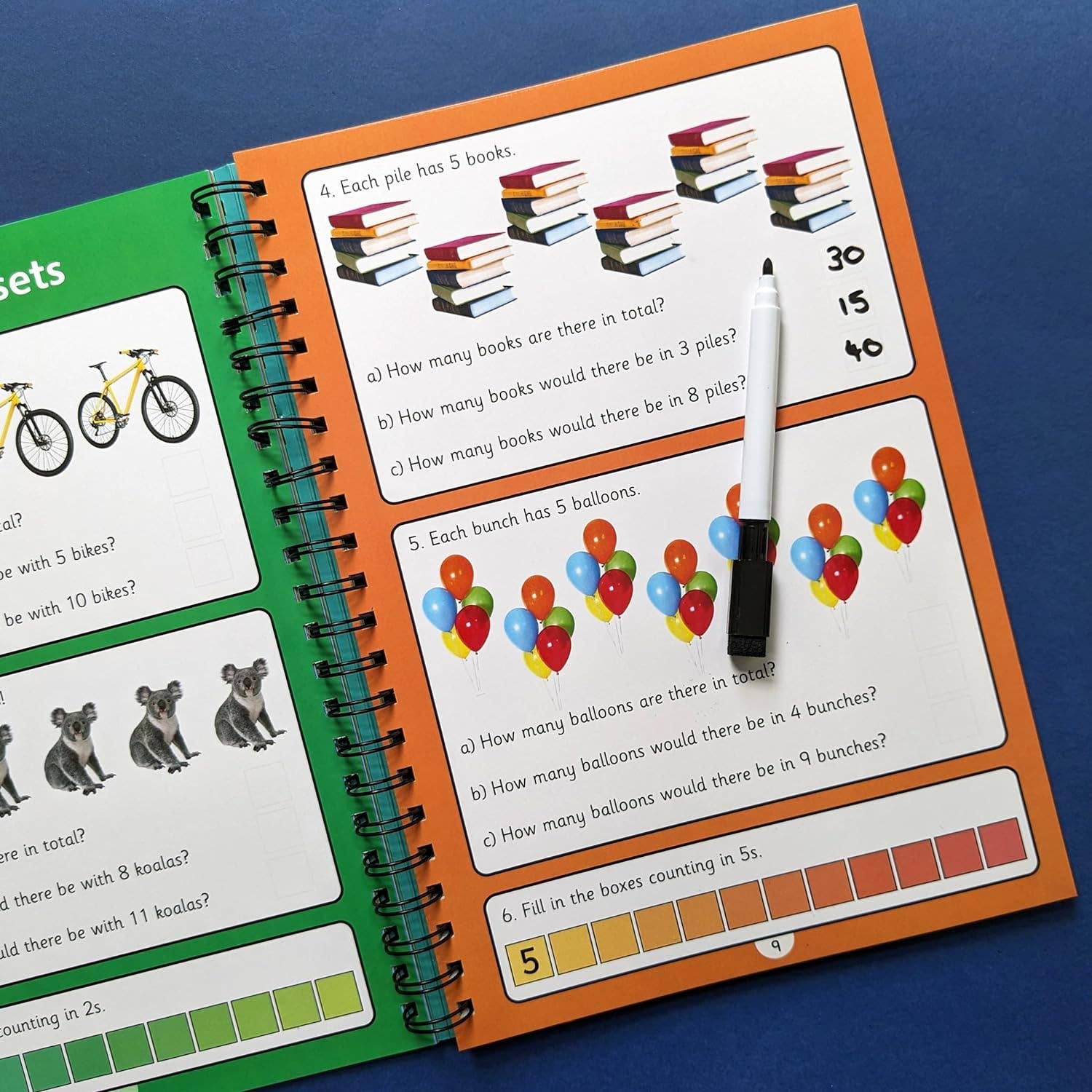 Educational book with math problems and a marker on a blue background