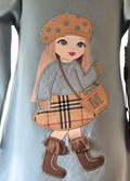 Embroidered patch of a girl in a plaid dress and brown boots on a light blue background
