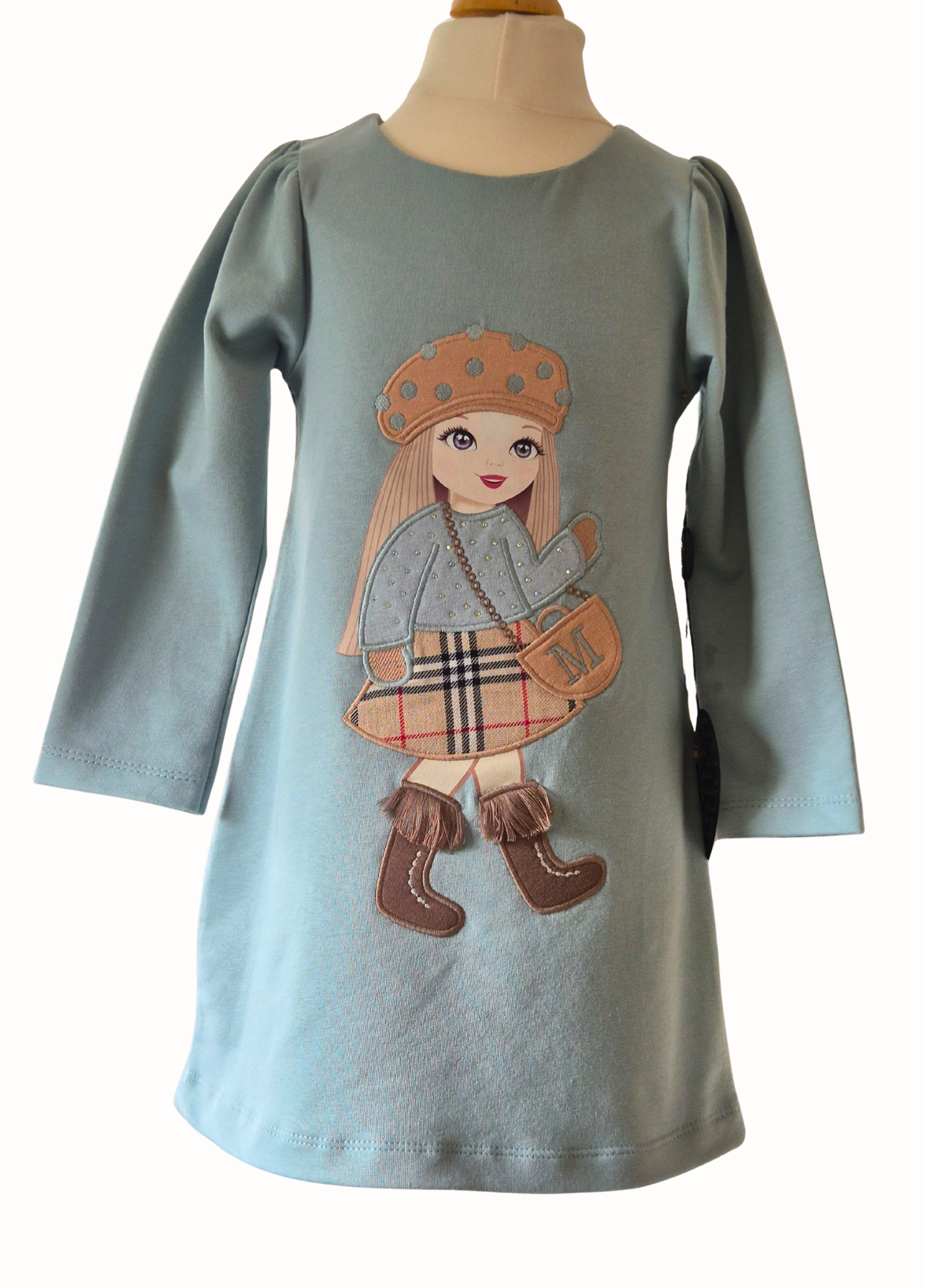 Children's dress with a printed design of a girl on a mannequin against a white background