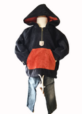 Black distressed jeans with two-tone hoodie with black and rust design on a mannequin against a white background