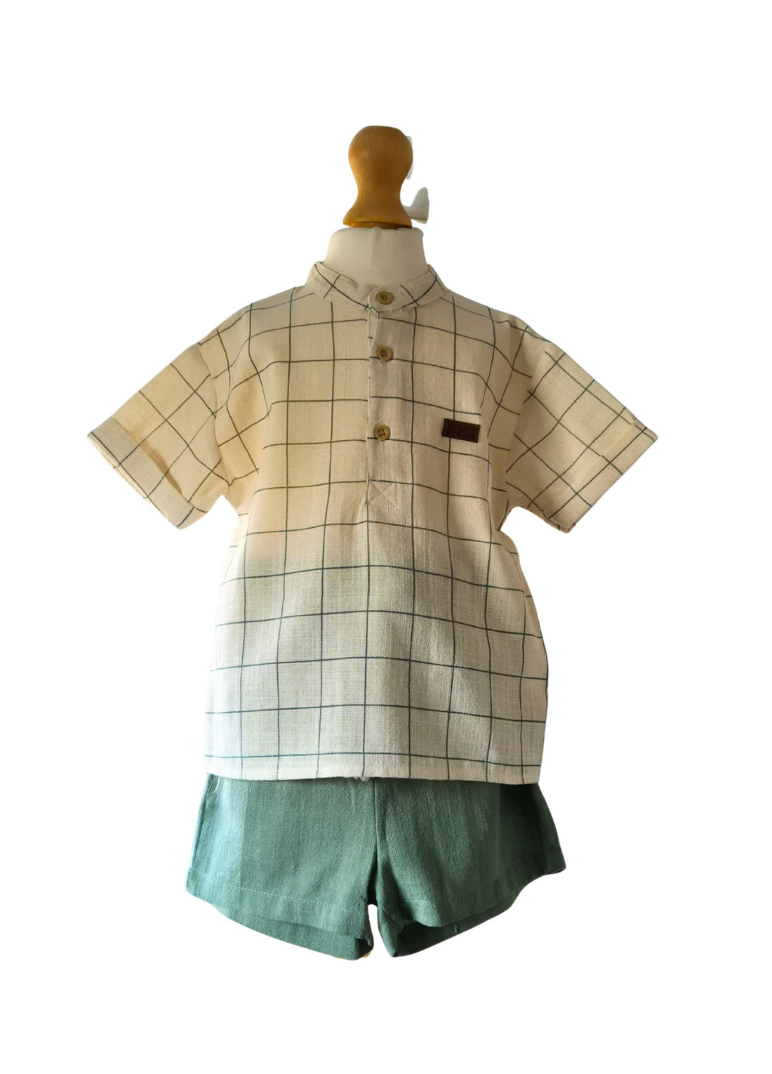 Young boy in a natural and green striped shirt with grandad collar and a co ordinating pair of green linen shorts