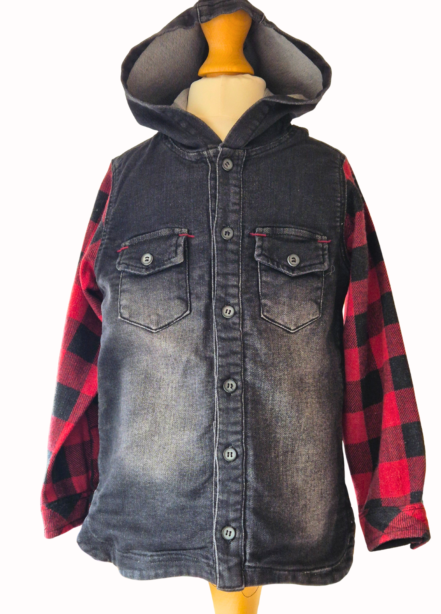 Denim shirt with red plaid sleeves on a mannequin against a white background