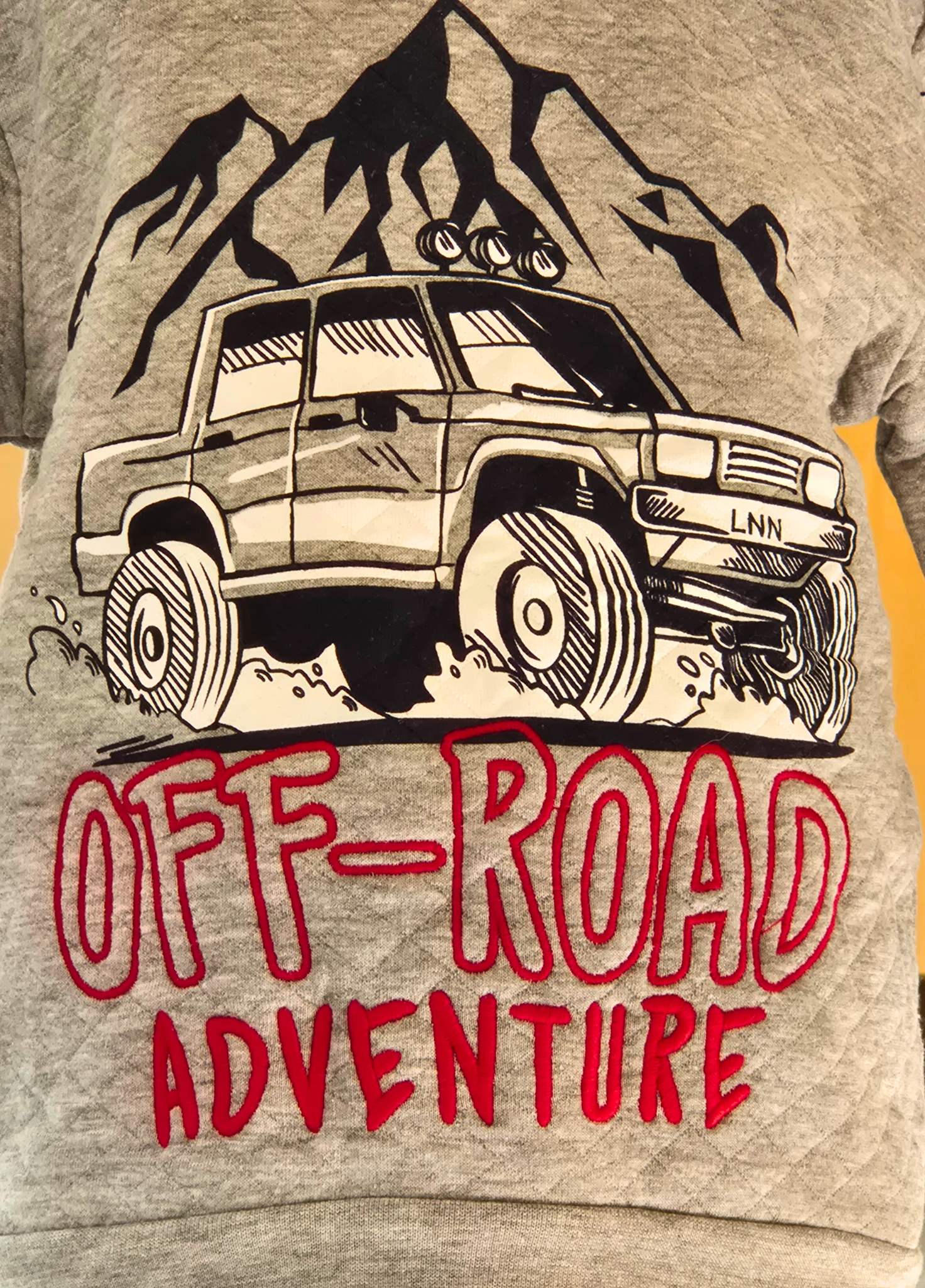 Gray t-shirt with an off-road vehicle graphic and 'Off-Road Adventure' text on a yellow background