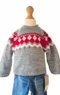 Close up of gray sweater with red and white pattern on a mannequin against a white background