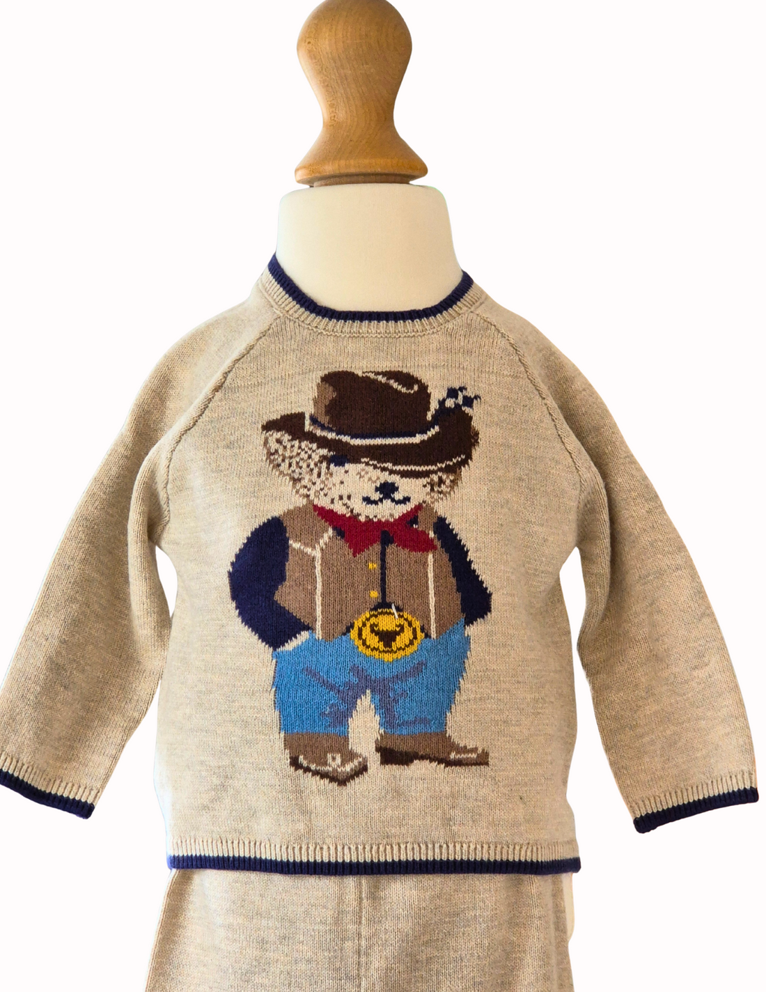 Knitted jumper with a cowboy bear design and matching trousers on a white background
