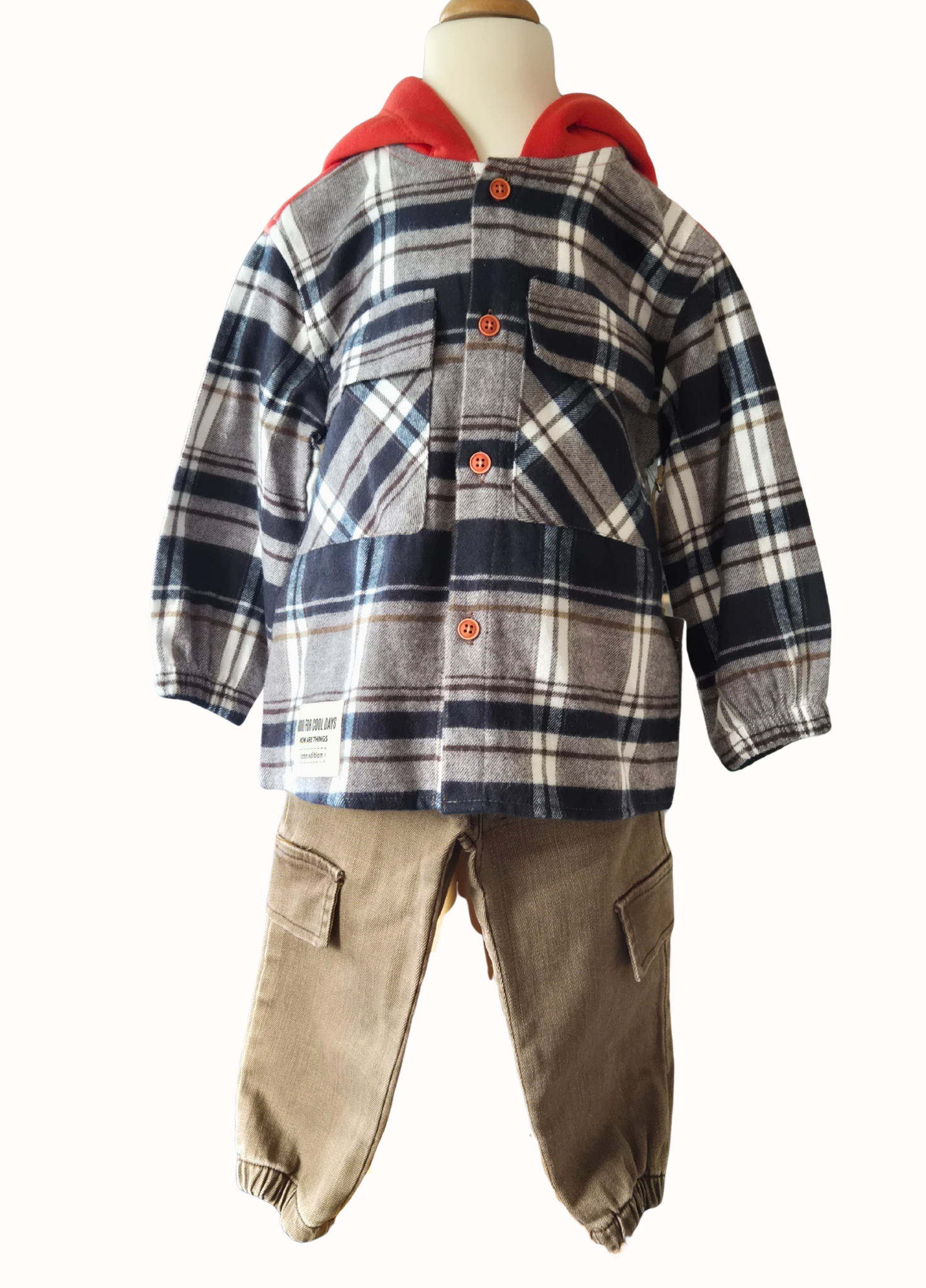 Children's plaid shirt with orange hood and beige pants on a mannequin against a white background