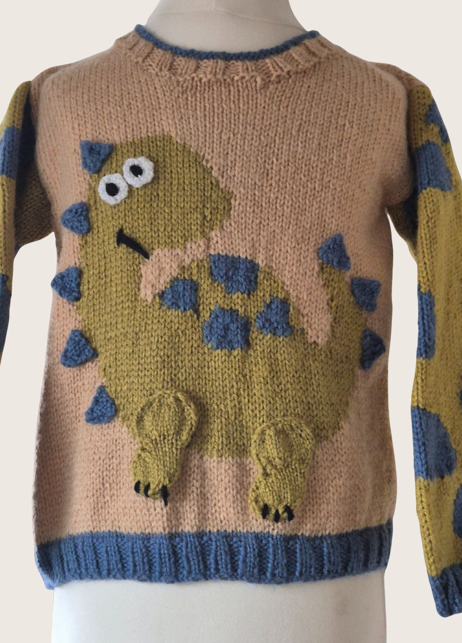 Knitted sweater with dinosaur design on a mannequin
