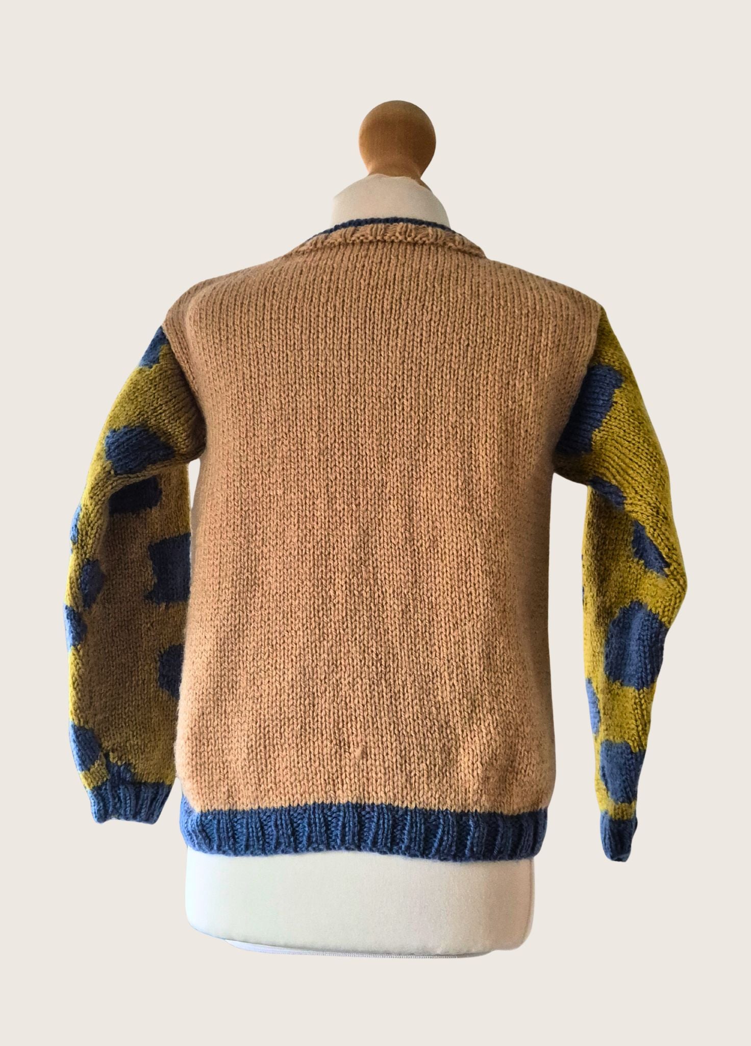 Knitted sweater with a pattern on a mannequin against a plain background