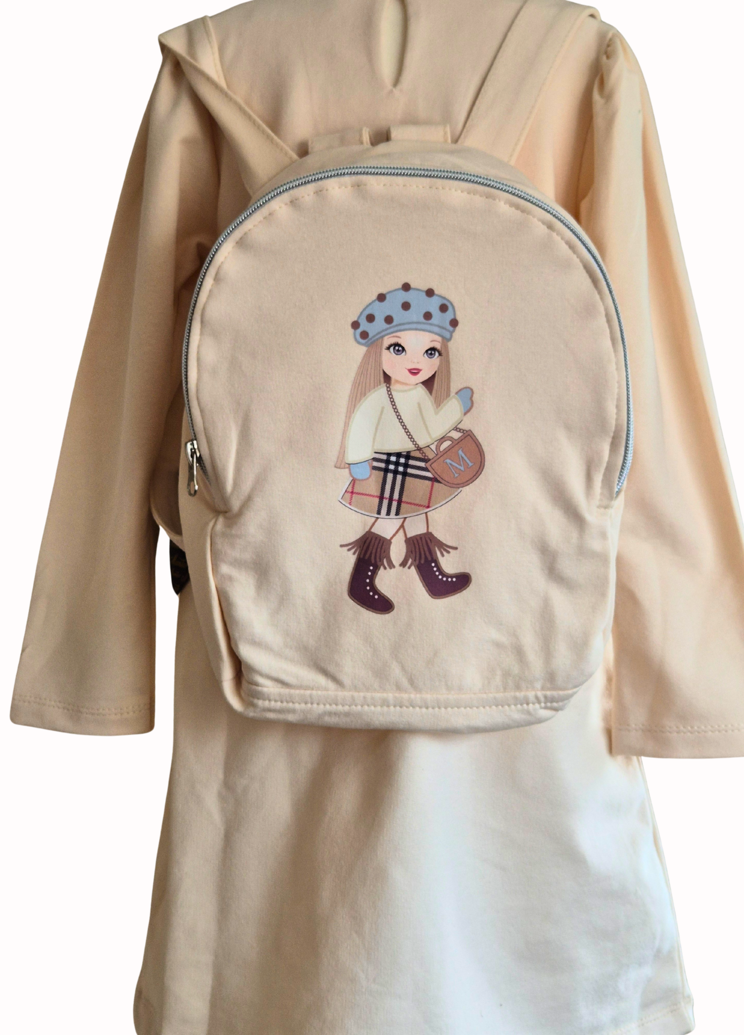 A  cream matching back pack showing the same doll motif 