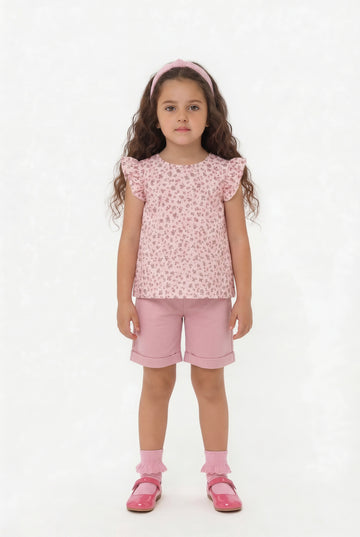 Girls dusky pink knee length shorts and floral floaty top summer outfit.
