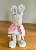 Plush Flopsy rabbit toy with a pink cape on a wooden surface