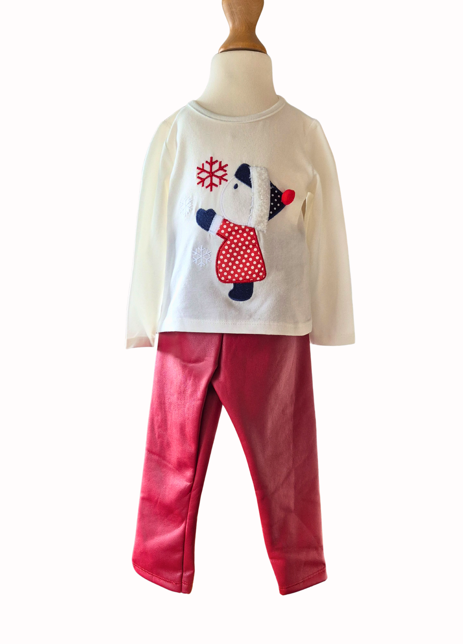 Children's outfit with a white top featuring a little gir; design and red pants on a mannequin against a white background.