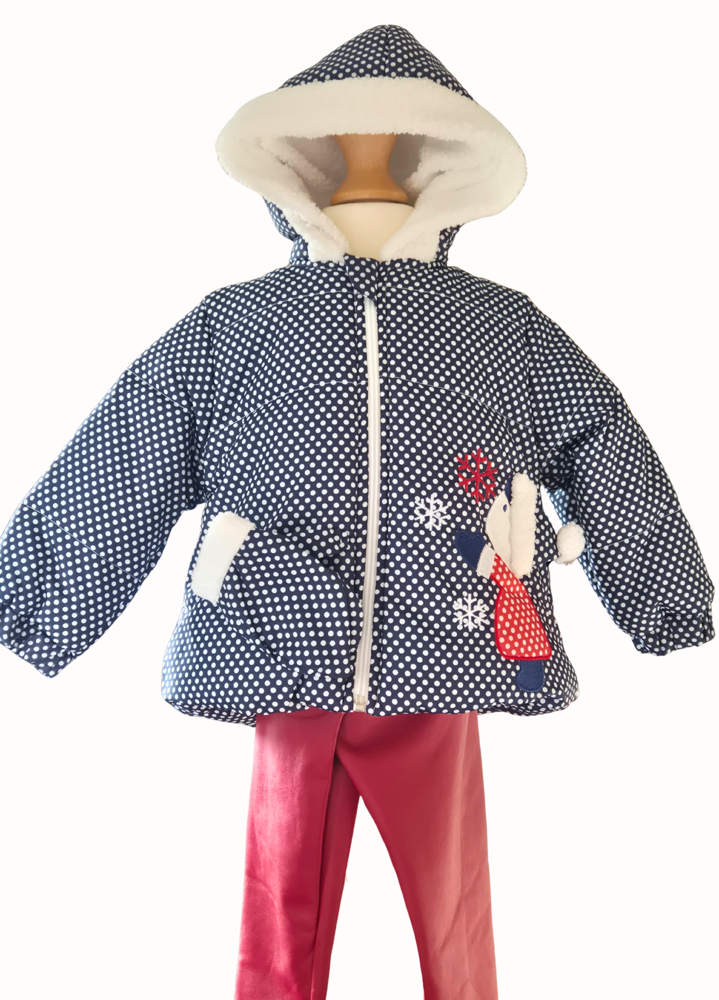 Children's navy polka dot jacket with white lining on a mannequin against a white background