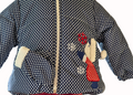 Children's polka dot jacket with winter-themed patches on a white background