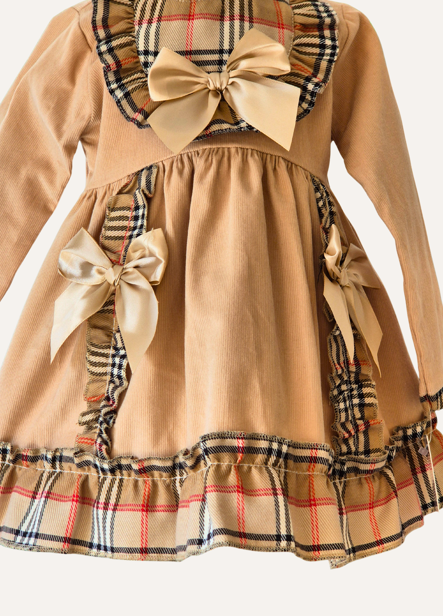 Detail of the Spanish Beige dress with plaid accents with bows and frills