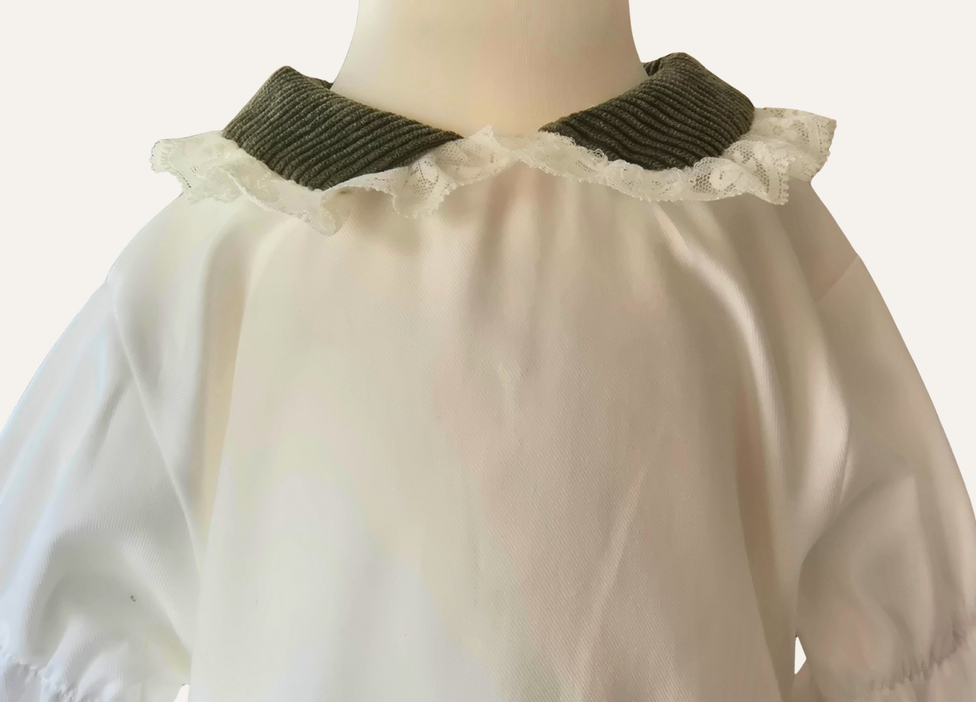 Close up detail of lace and olive green trim collar on spanish girls blouse