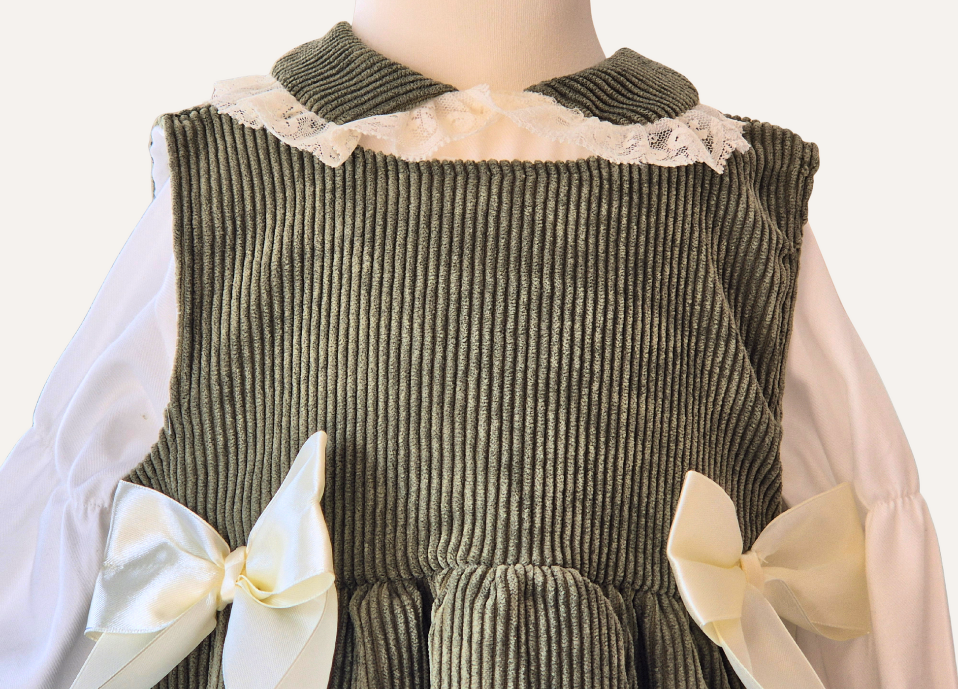 Close up detail of Girls Spanish Olive corduroy pinafore dress with matching lace collar blouse
