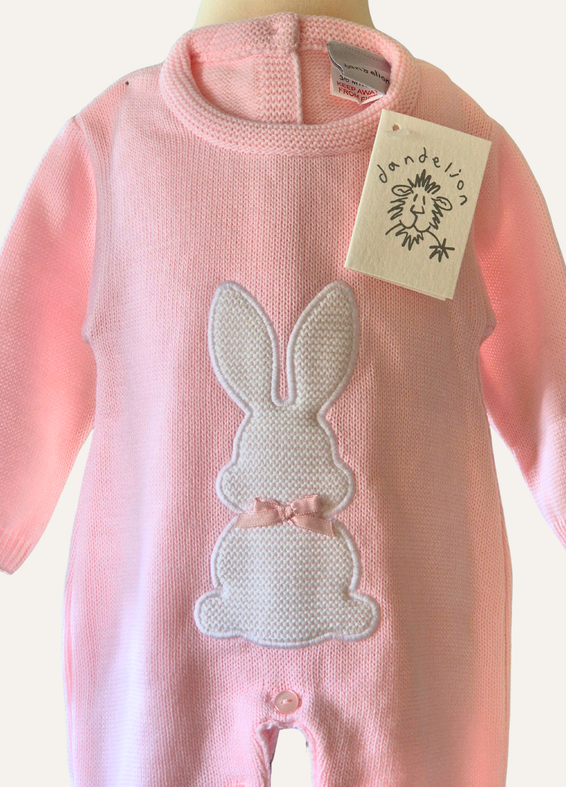 Baby pink knitted onesie from Dandelion with White rabbit detail