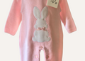 White rabbit motif on a baby pink knitted romper from Dandelion