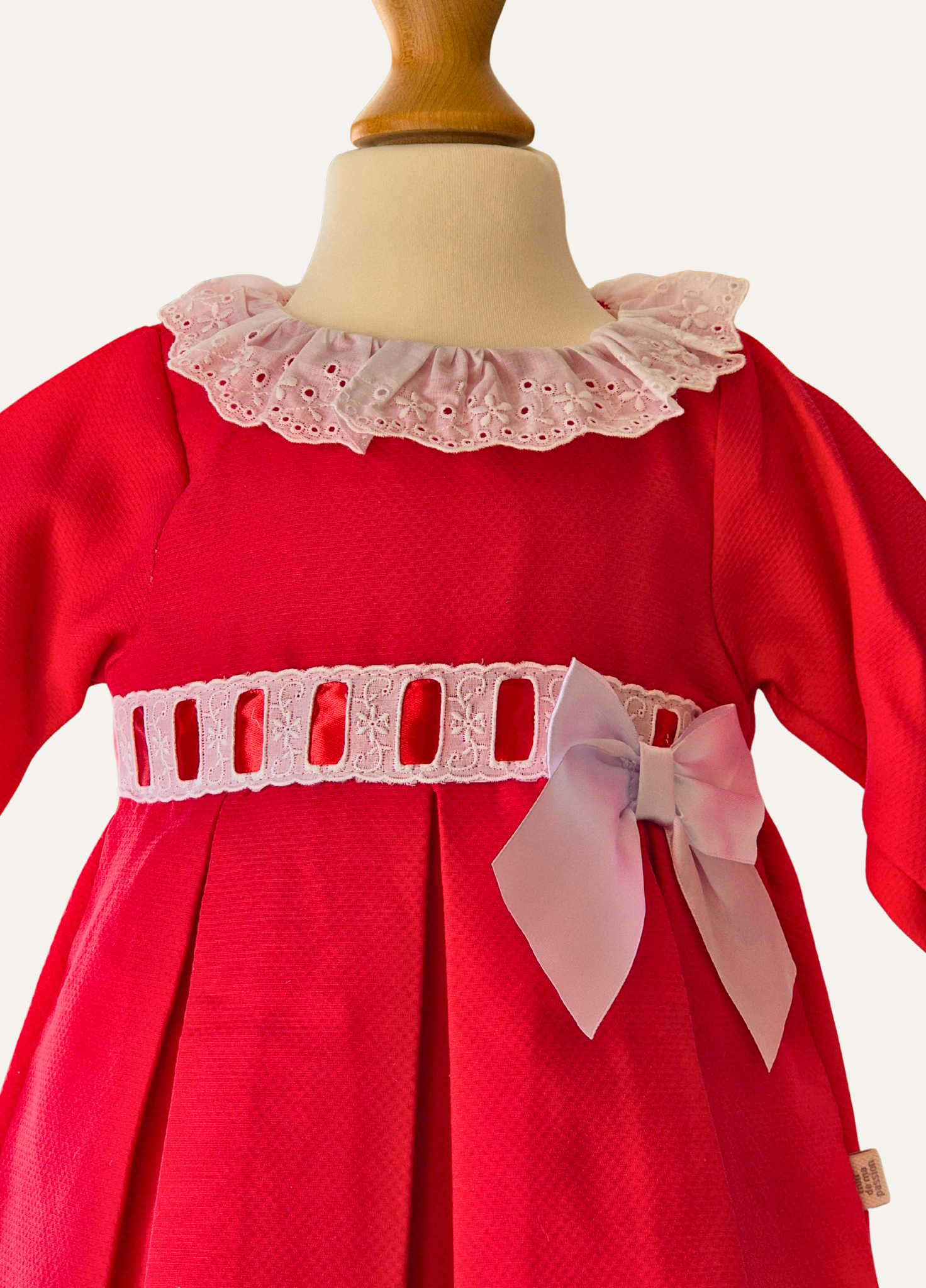 Bodice detail of girls Spanish  red dress with lace collar and white bow 