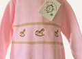 Close up of rocking horse detail on a baby pink knitted romper from Dandelion
