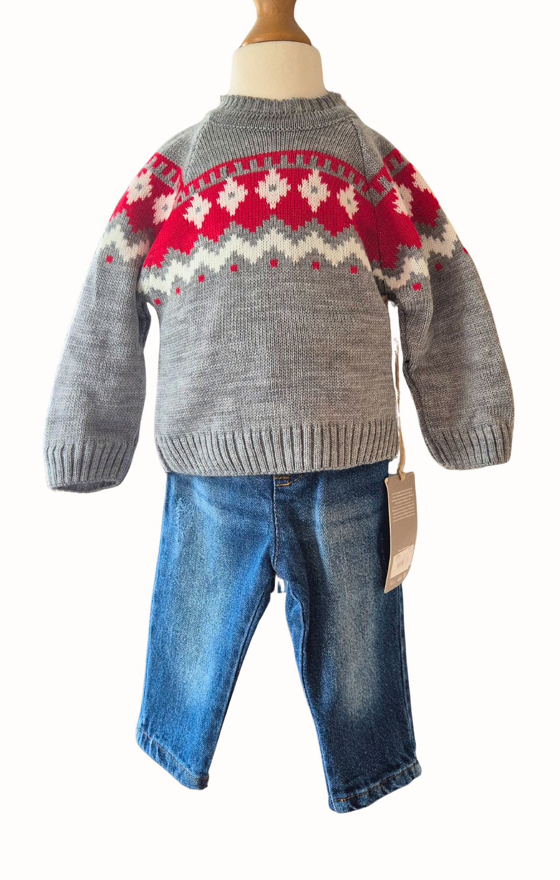 Children's outfit with gray sweater, red and white pattern, blue jeans, and checkered shirt on a mannequin.