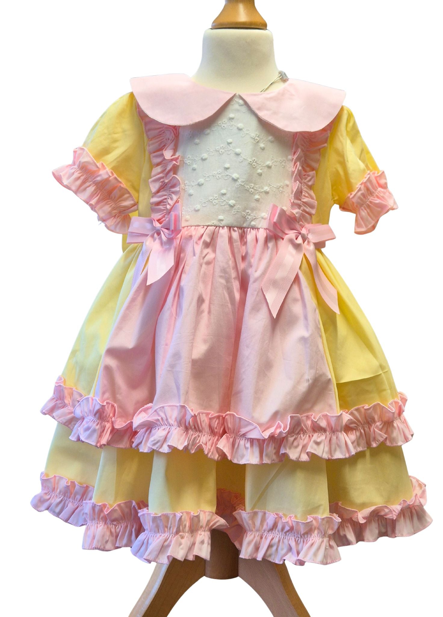 Pastel-colored dress with ruffles on a mannequin against a white background