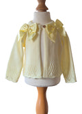 Lemon knitted cardigan with yellow bows on a mannequin against a white background