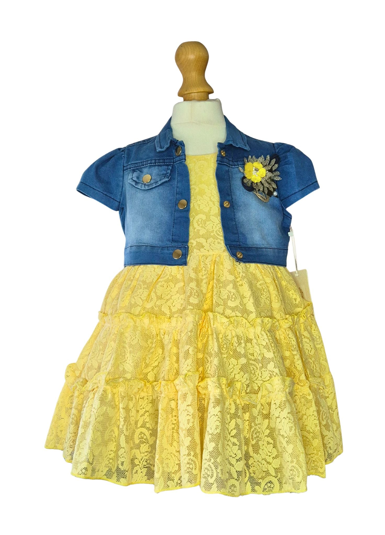 Yellow lace dress with denim shrug on a mannequin against a white background