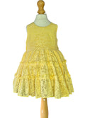 Yellow lace dress on a mannequin against a white background