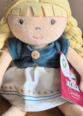 Bonikka organic  ragdoll with blonde hair and blue top, wearing a white dress with embroidery, on a brown background.