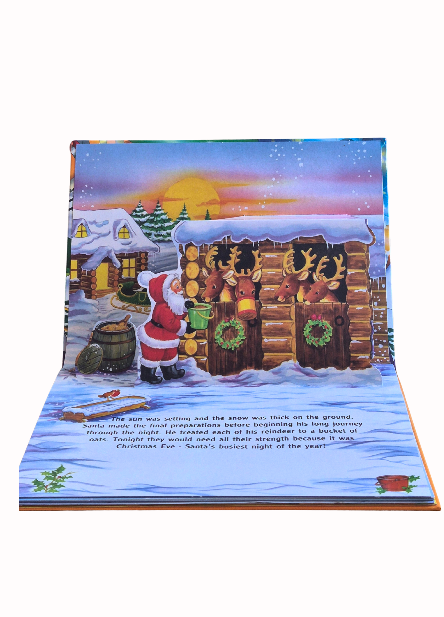 Pop-up Christmas book page with Santa Claus and reindeer in a snowy village scene.