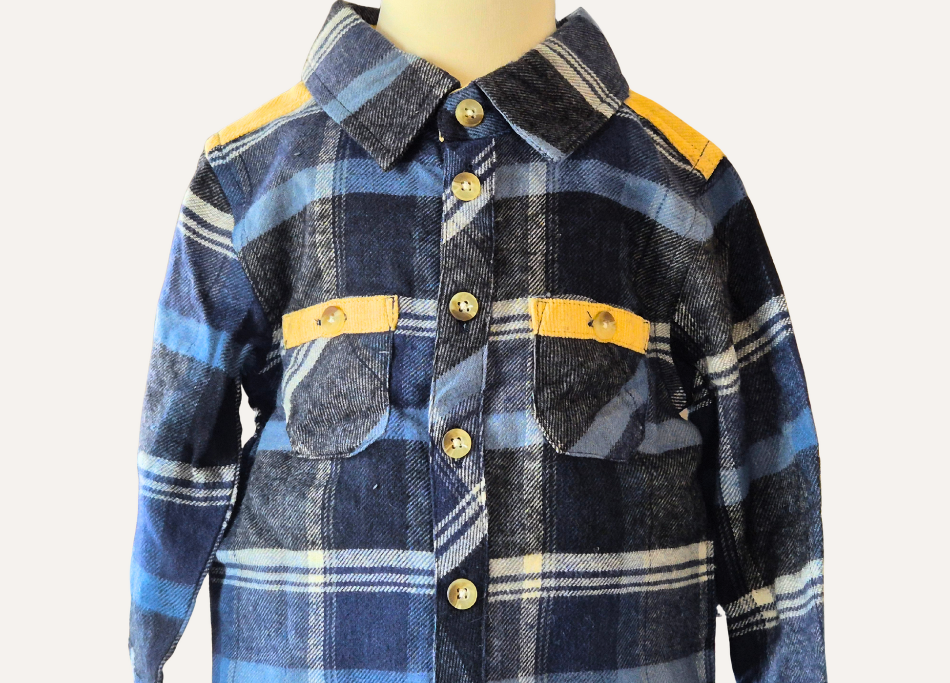 Close up of the mustard accents on the boys blue checked shirt which is  part of a 2piece set