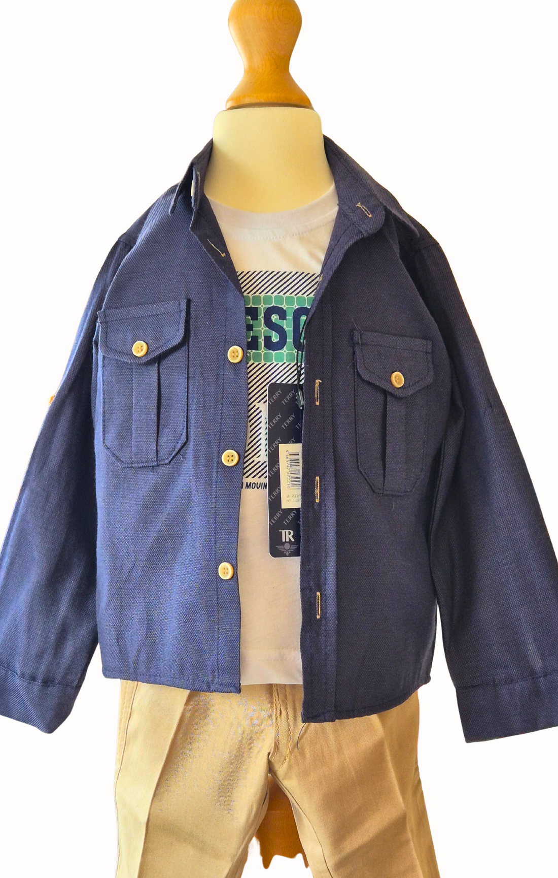 Children's outfit with navy shirtt, beige pants, and white t shirt on a mannequin against a white background