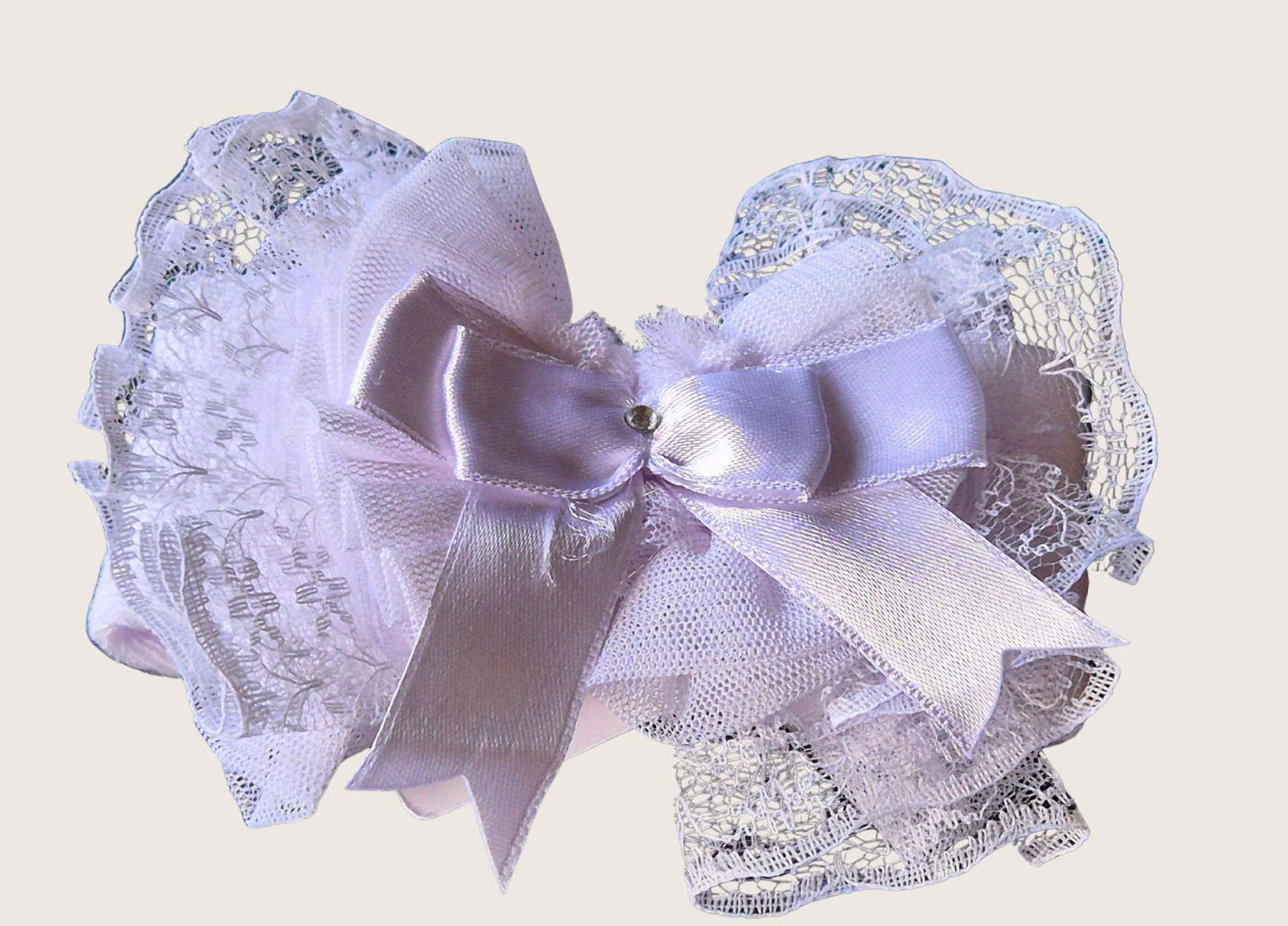 Babys headband with Decorative lace bow with a central ribbon on a light background