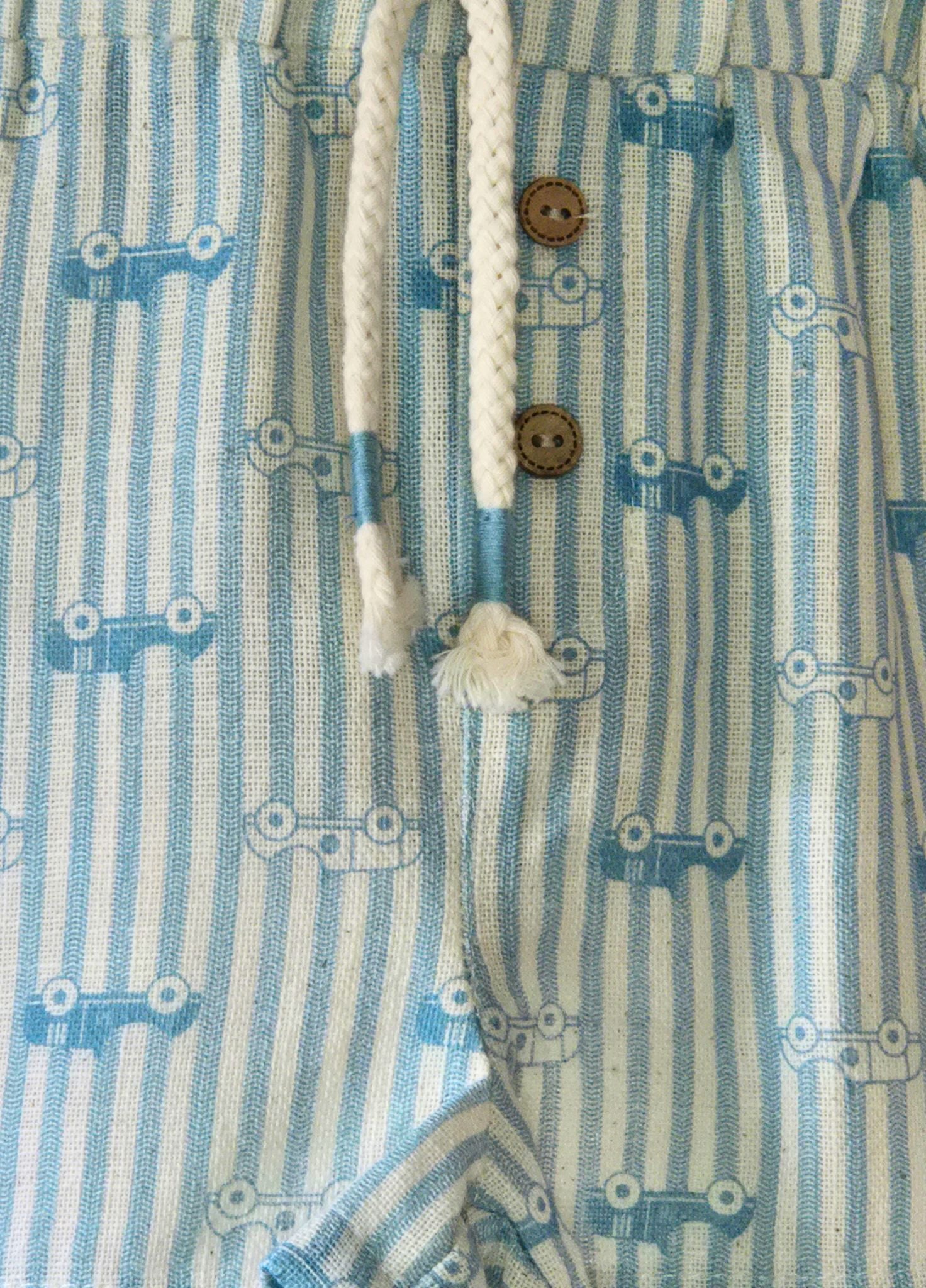 Close-up of a blue and white striped pair of shorts with buttons and drawstrings.