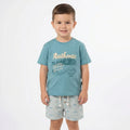 Child wearing a blue t-shirt with text and graphics on a white background