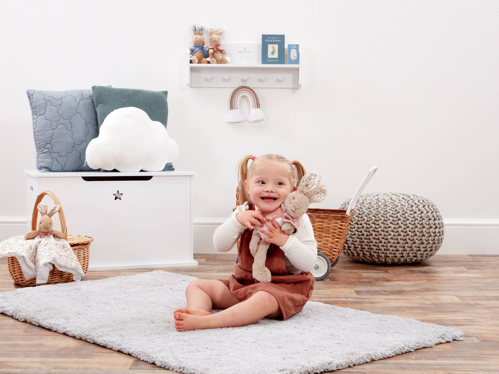 Child sitting on a rug in a room with toys and furniture