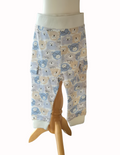 Baby pants with bear pattern on a wooden stand against a white background