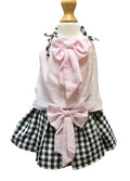 Children's outfit with pink top and plaid skirt on a mannequin against a white background