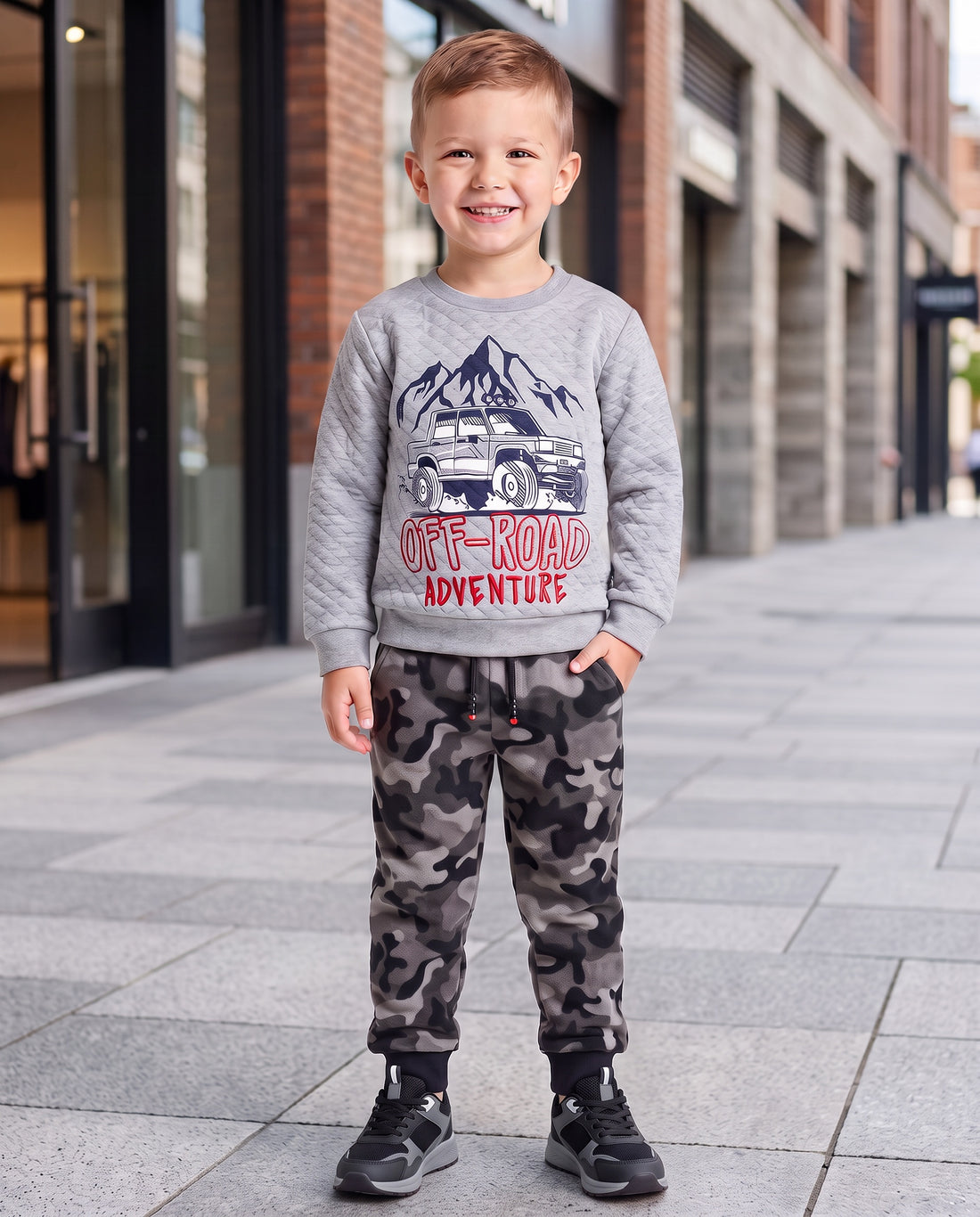 boy in grey and black camo joggers with a grey top with Off Road Adventures on the front
