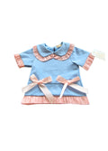 Light blue top  with pink ruffled collar and ribbons on a white background