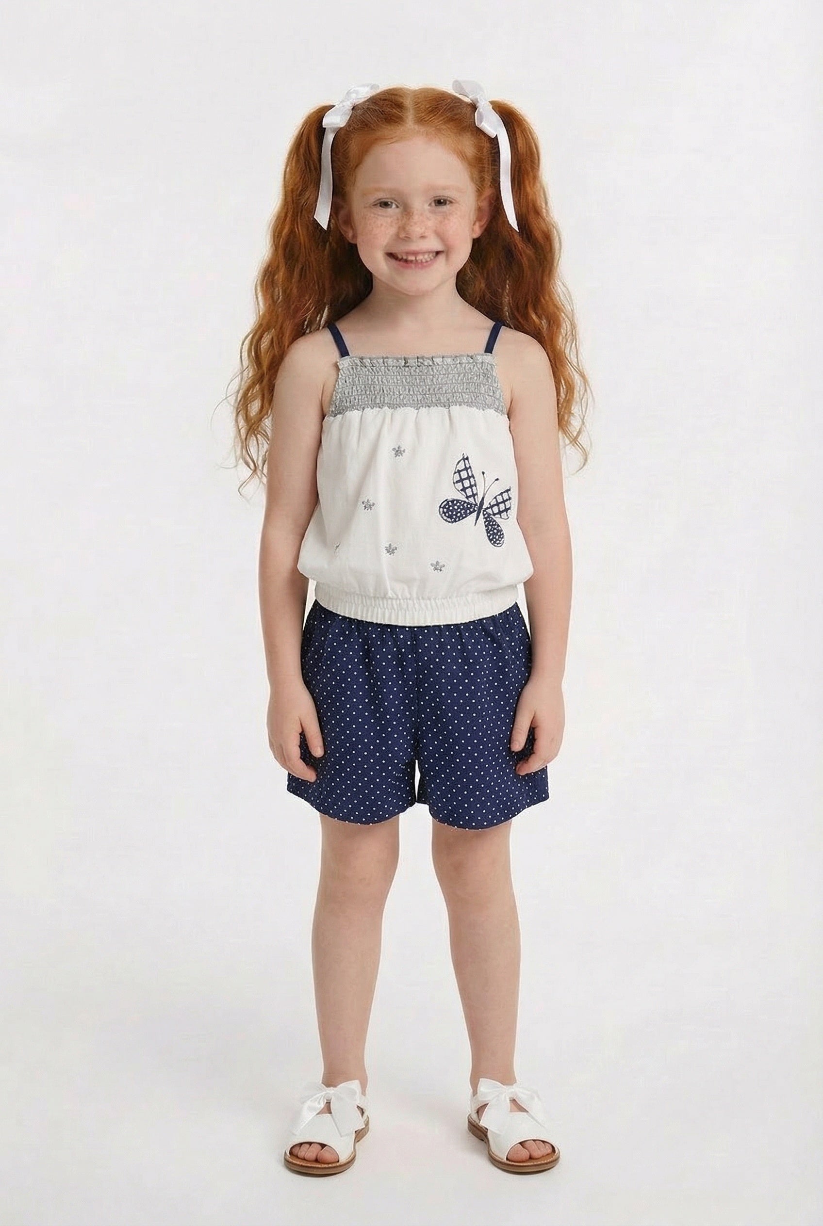 Children’s blue polka dot summer playsuit with butterfly detail